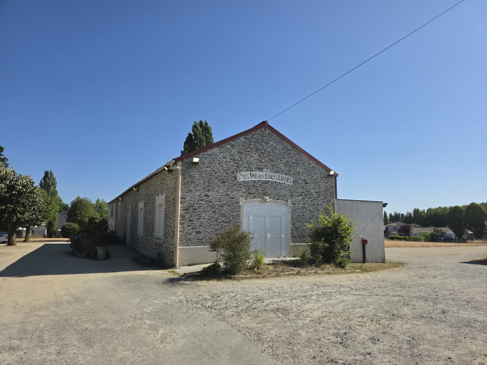 Façade de la salle Jean-Noël Prin avec l'inscription Les Amis des Écoles Laïques